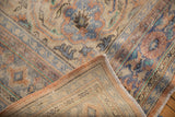 Distressed vintage Oushak carpet's worn pile and hand-knotted foundation in rust, blue, ivory.