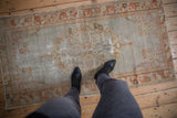 Distressed vintage Oushak rug, faded field with floral designs and blossom and leaf border.