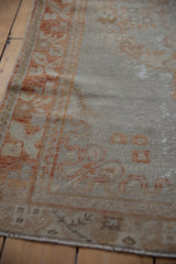 Distressed vintage Oushak rug border featuring pale rust and beige blossom motifs.