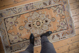 Distressed Oushak rug, central starburst floral medallion, softened pile, and muted orange-gray tones.