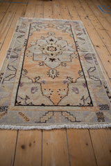 Distressed vintage Oushak rug showcasing its bold central medallion and abrashed pale orange field.
