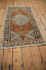 Distressed pile texture and side border of dusty rust, beige, and bronze vintage Oushak runner.