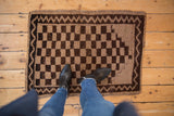 Distressed checkerboard pattern in chocolate brown and beige with a zig-zag border.