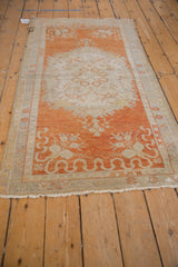 Distressed vintage Oushak rug, faded tangerine orange blossom and leaf border, ivory spandrel.