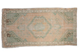 Distressed vintage Oushak rug with a large seafoam green medallion and spandrels on a beige field.