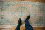 Overhead view showing the scale and worn texture of a distressed vintage Oushak rug.