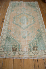 Angled perspective of a vintage distressed Oushak rug, showing the soft pile and faded colors.
