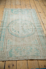 Distressed vintage Oushak runner detail: ivory and pale turquoise pattern with visible foundation.