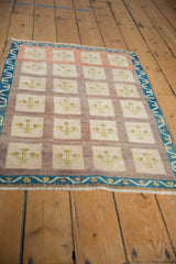 Distressed Turkish Oushak rug with muted ivory, mauve, indigo multi-paneled tree design.