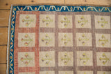 Distressed Oushak rug corner with indigo vine border, terracotta, and ivory multi-paneled design.
