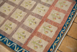 Distressed vintage Oushak rug corner with indigo vine border and beige tree of life panels.