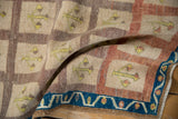 Distressed vintage Oushak rug close-up highlighting indigo blue vine border and textured pile.