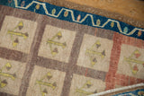 Distressed vintage Oushak rug, blue vine border, beige panels with tree of life motifs.