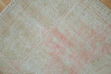 Distressed hand-knotted Oushak rug pile with mostly even wear, featuring blush and ivory tones.