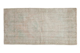 Distressed vintage Oushak rug, faded roundel medallion, ivory, beige, and pale green tones.