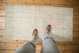 Worn vintage Oushak rug texture in soft ivory, beige, and pale sea foam green.