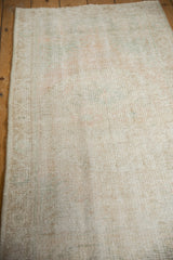 Distressed vintage Oushak rug detail, showing worn pile, visible foundation, and soft colors.