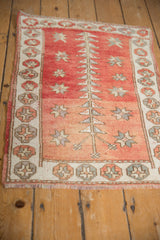 Distressed Oushak rug mat, worn pile showing geometric plant and starburst motifs.