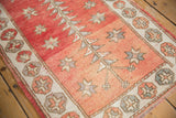 Distressed Oushak rug: abrashed dusty rose field with geometric plant motifs and pomegranate border.