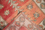 Distressed Oushak rug corner showing worn dusty rose pile and detailed foundation weave.