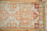 Distressed pile on an ivory, terracotta, and saffron geometric vintage Oushak rug.