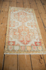 Distressed vintage Turkish Oushak rug with geometric double medallions in ivory, terracotta, saffron.