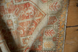 Distressed vintage Oushak rug with textured wool pile, brick red, ivory patterns, and selvage.