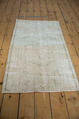 Distressed vintage Oushak rug showcasing worn pile, subtle patterns, and intact side selvage.