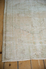 Distressed Oushak rug shows worn pile, visible foundation, and intact side selvage.