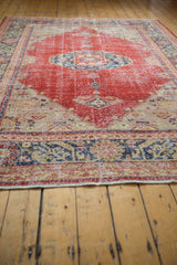 Distressed cherry red Oushak carpet border with navy, beige geometric pattern, mostly even wear.