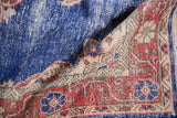 Distressed cobalt blue field with worn knot heads and faded rust palmette motif.
