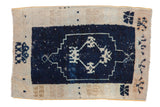 Decorative distressed vintage Oushak rug mat, navy blue field, stylized floral motifs, beige border.