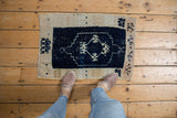 Distressed hand knotted Turkish Oushak rug mat with fading navy and ivory patterns.