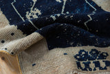Distressed vintage Oushak rug showing navy pile texture, exposed foundation, and side cord.