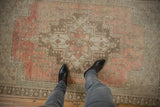 Distressed vintage Oushak rug showing soft rose, blush, and time-softened beige tones.