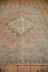 Rose and beige concentric medallion with faded plant motifs on vintage Oushak rug.