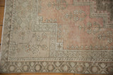 Distressed Oushak rug corner: blush field, beige and oxidized silver borders with tiny plant motifs.
