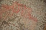 Muted rose and blush field of a distressed vintage Oushak rug with subtle plant motifs.