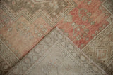 Distressed Oushak rug showing worn rose, blush, beige pile with visible hand-knotted foundation.