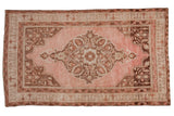 Distressed Turkish Oushak rug, blush field with elaborate coffee brown medallion and corner spandrels.