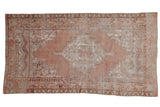 Hand-knotted vintage distressed Oushak rug with faded dusty mauve and ivory medallion.