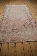 Decorative end detail of a vintage Oushak rug with serrated motifs and significant wear.