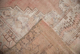 Vintage Oushak rug's worn, distressed pile and reverse in dusty mauve, ivory patterns.