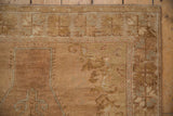 Distressed vintage Oushak rug border featuring starburst motifs, muted colors, and visible foundation.
