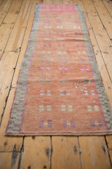 Vintage distressed Oushak runner with dusty blush field, geometric patterns, and visible abrashes.