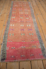 Distressed Oushak rug runner displaying geometric floral motifs in blush, pink, mint green, and abrash.