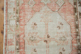 Distressed Oushak runner close-up, showing side edge with mostly intact selvage and muted red-beige patterns.