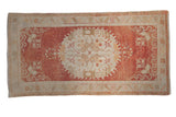 Distressed vintage Oushak rug featuring an ivory central medallion on an abrashed cinnabar red field, 3'4