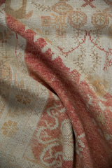 Distressed vintage Oushak rug pile, highlighting even wear and pale cinnabar red hues.