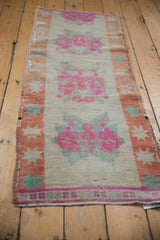 Pink and fuchsia rose bouquets with seafoam green details on distressed Oushak runner.